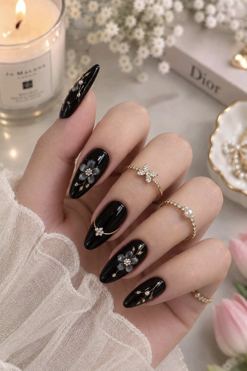 Long glossy black oval nails with smoky grey 3D flowers, pearls and thin gold lines