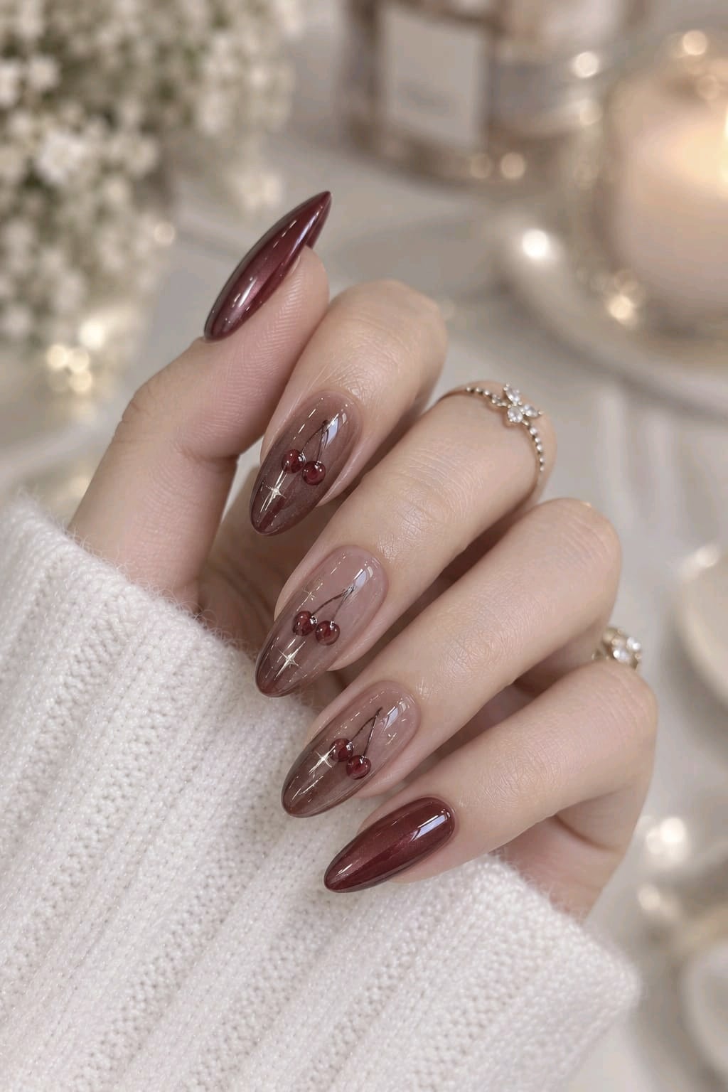 Cherry mocha cat eye almond nails with sheer brown accent nails, painted cherries and sparkles